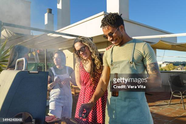 spanish group of millennial people cooking a barbecue birthday celebration outdoors laughing at summer time - madrid stock pictures, royalty-free photos & images
