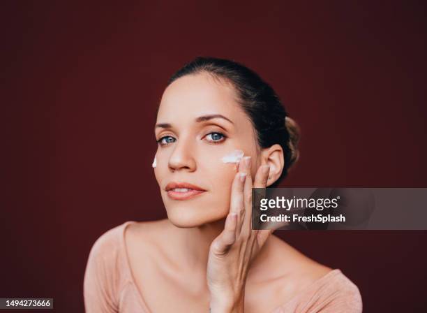 portrait of a beautiful happy woman with face cream on her cheek - blackheads on face stock pictures, royalty-free photos & images