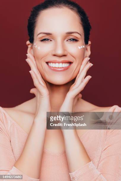 portrait of a beautiful happy woman with face cream on her cheek - pores stockfoto's en -beelden