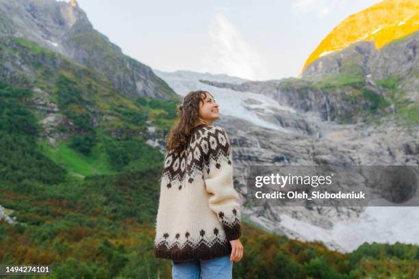 woman standing on the background of jostedalsbreen glacier - scandinavian descent stock pictures, royalty-free photos & images