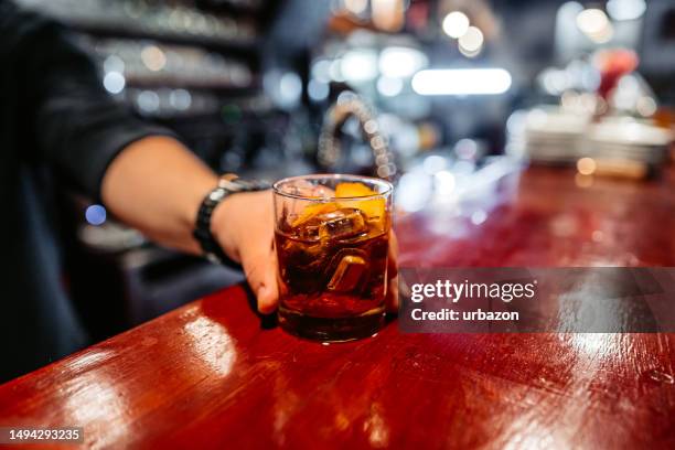 bartender serving whiskey on a bar counter - rum stock pictures, royalty-free photos & images