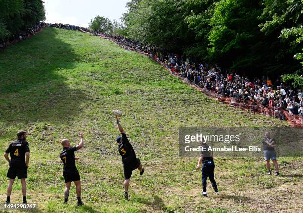 Rugby players prepare to tackle participants prior to the annual Cooper's hill Cheese races on May 29, 2023 in Gloucester, United Kingdom. This year,...