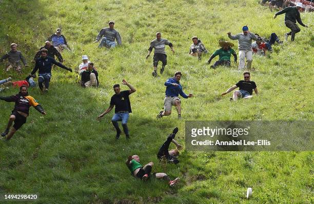 Participants take part in the second Cooper's hill men's downhill race on May 29, 2023 in Gloucester, United Kingdom. This year, with no police or...