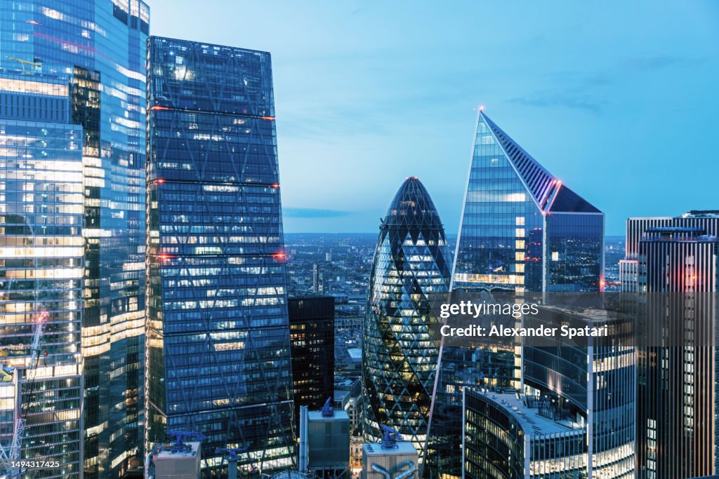 City of London skyline illuminated at dusk, aerial view, UK