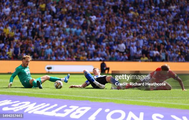 Michael Smith of Sheffield Wednesday has his shot blocked by Harvey Isted of Barnsley as teammate Mads Juel Andersen looks on during the Sky Bet...
