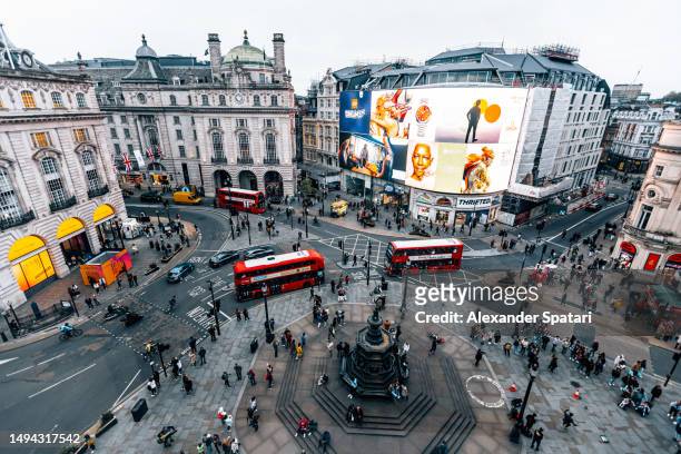 aerial wide angle view of piccadilly circus with red double-decker buses and multiple ads - piccadilly stock-fotos und bilder
