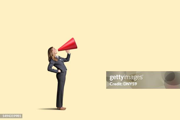 woman with megaphone on yellow background - megaphone stock pictures, royalty-free photos & images