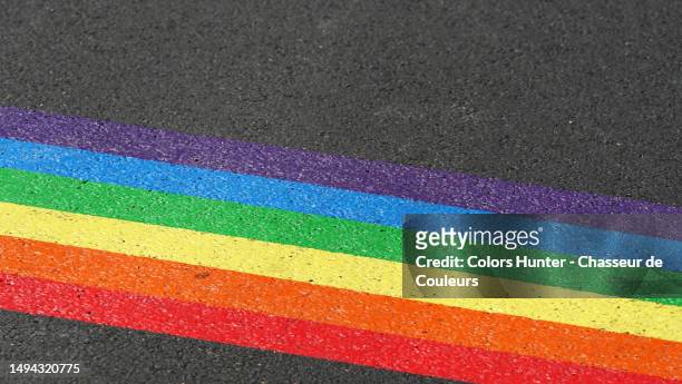 the rainbow flag of the lgbt+ community painted on the tarmac of a street in paris, france - all love is equal fotos in paris stockfoto's en -beelden