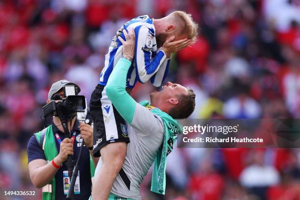 Barry Bannan of Sheffield Wednesday celebrates with teammate David Stockdale after the team's victory and promotion to the Sky Bet Championship in...