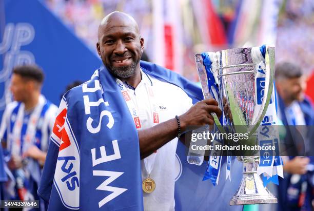 Darren Moore, Manager of Sheffield Wednesday, celebrates with the trophy after the team's victory and promotion to the Sky Bet Championship in the...