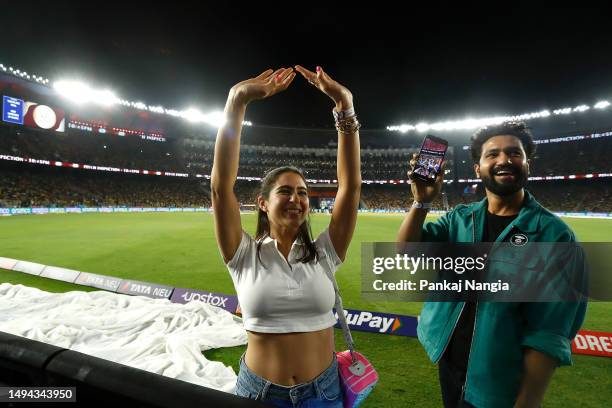 Bollywood actors Sara Ali Khan and Vicky Kaushal pose on the boundary during a rain delay of the 2023 IPL Final match between Chennai Super Kings and...