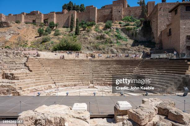 Tourists view the Roman Theatre in front of the Alcazaba fortress in the old town on April 16, 2023 in Malaga, Spain.