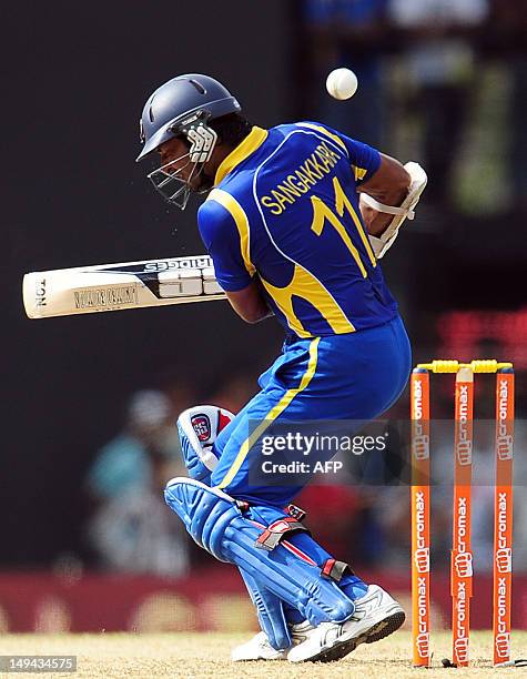 Sri Lankan cricketer Kumar Sangakkara reacts after been hit on it off the ball of unseen Indian cricketer Ashok Dinda during the third one day...