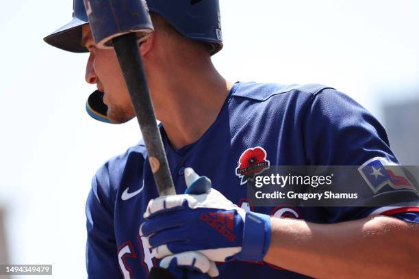 Corey Seager of the Texas Rangers prepares to bat on the first inning with a red poppy on the left side of his jersey with “Lest We Forget” in honor...