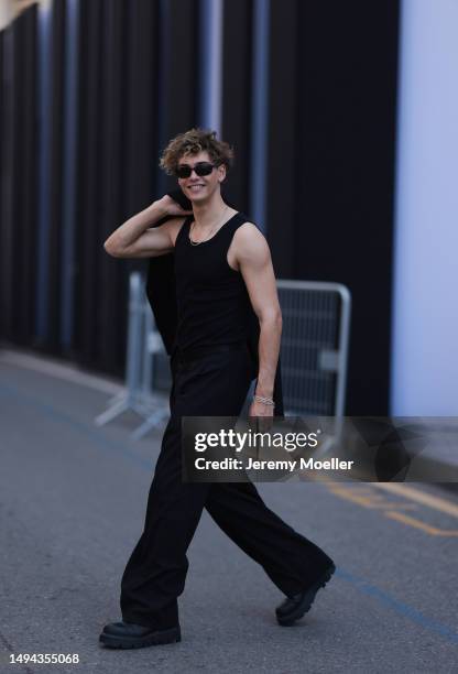 Bene Schulz is seen wearing a complete black look, black tanktop, black pants, black shades and black shoes and a black blazer and silver necklace...