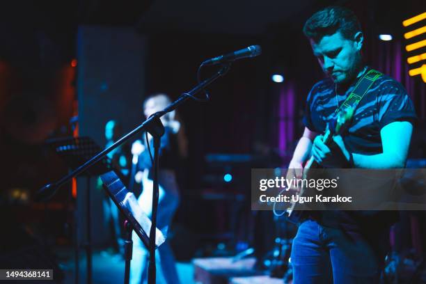 musicisti che suonano la chitarra elettrica e cantano sul palco - music pub foto e immagini stock