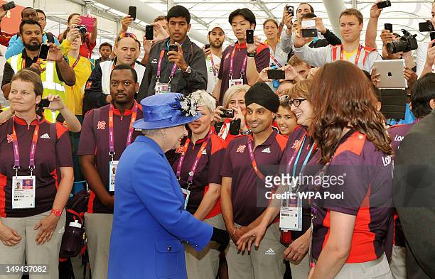 Queen Elizabeth II visits the Athletes Village dinning hall during a tour of the Olympic site on day one of the London 2012 Olympics Games on July...