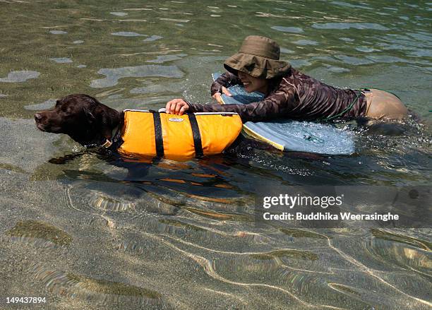 Japanese woman and her pet dog bath swim at Takeno Beach on July 28, 2012 in Toyooka, Japan. This beach is especially open for dogs and their owners...