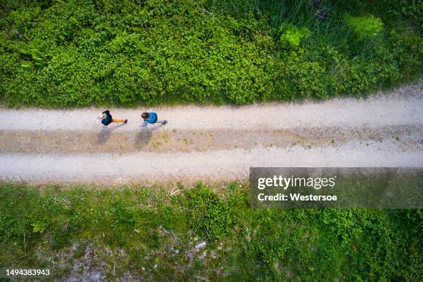 two people walking on dirt road - spring denmark stock pictures, royalty-free photos & images