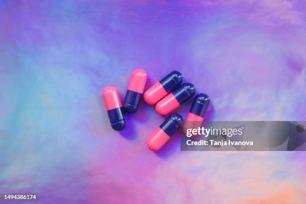 colorful pills on neon background. taking tablets, capsules, vitamins, painkillers, medications and dietary supplements. minimal medical, health care, pharmacology concept. flat lay, top view. - tranquilizing stock pictures, royalty-free photos & images