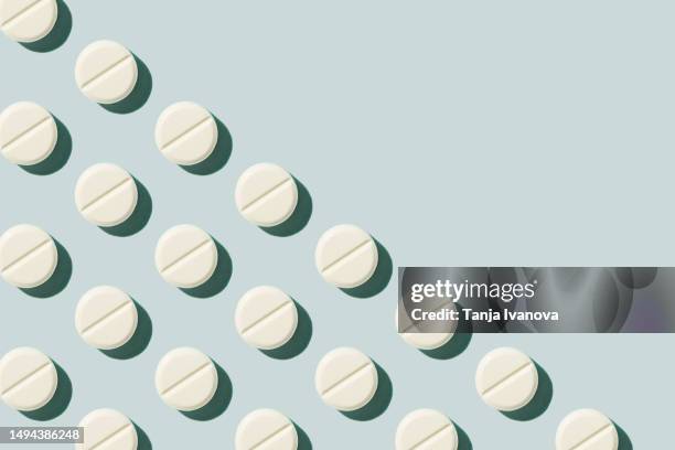 pattern of white pills on blue background. taking tablets, capsules, vitamins, painkillers, medications and dietary supplements. minimal medical, health care, pharmacology concept. flat lay, top view, copy space - pills stock pictures, royalty-free photos & images