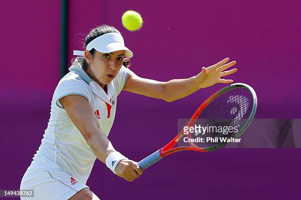 Christina Mchale of the United States return a shot against Ana Ivanovic of Serbia on Day 1 of the London 2012 Olympic Games at the All England Lawn...