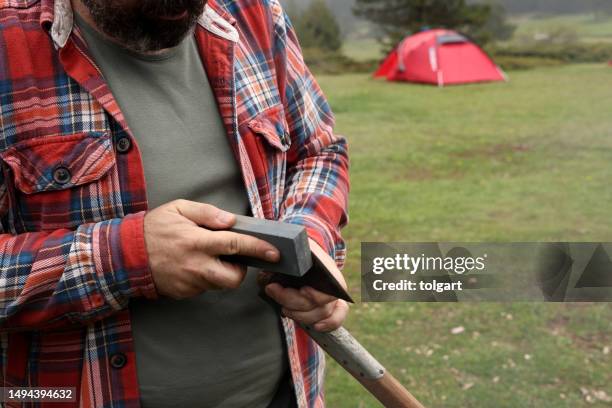man checking axe sharp edge - scherp stockfoto's en -beelden