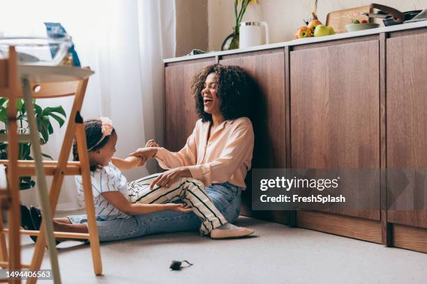 a happy beautiful mother having fun with her pretty baby girl at home - wide angle stockfoto's en -beelden