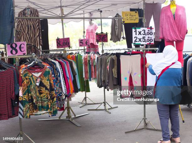 lyon, france: woman shops for clothing outside, quai saint antoine - lyon shopping stock pictures, royalty-free photos & images