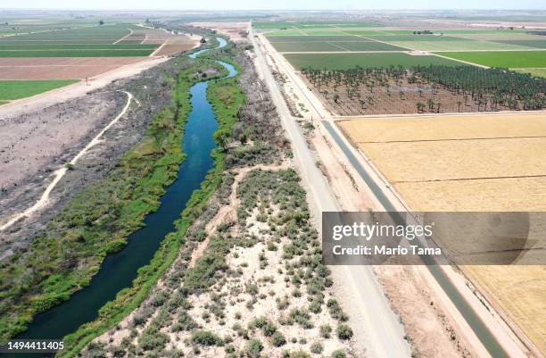 An aerial view shows the long-depleted Colorado River as it flows between California and Arizona, and an irrigation ditch carrying river water toward...