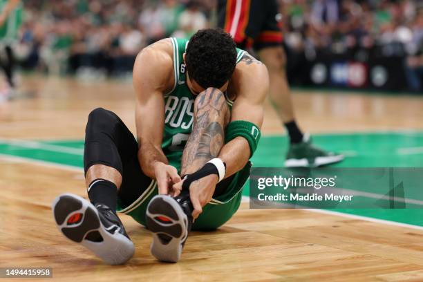 Jayson Tatum of the Boston Celtics grabs his ankle during the first quarter against the Miami Heat in game seven of the Eastern Conference Finals at...