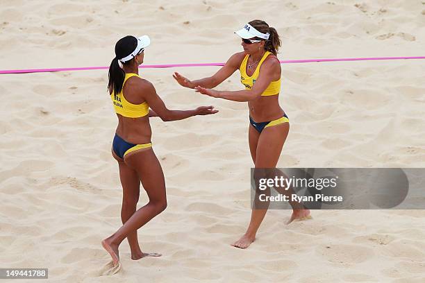 Larissa Franca and Juliana Silva of Brazil celebrate during the Women's Beach Volleyball Preliminary Round on Day 1 of the London 2012 Olympic Games...
