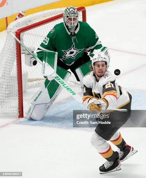 Brett Howden of the Vegas Golden Knights and Jake Oettinger of the Dallas Stars track a loose puck in the air during the first period in Game Six of...