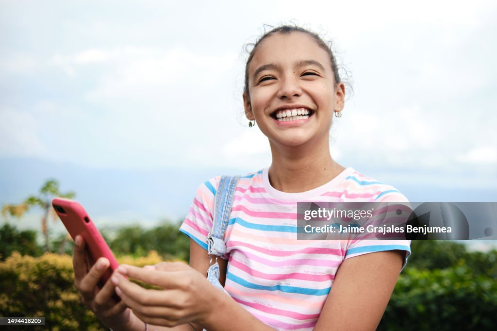 L'adolescente ride con il cellulare nelle sue mani