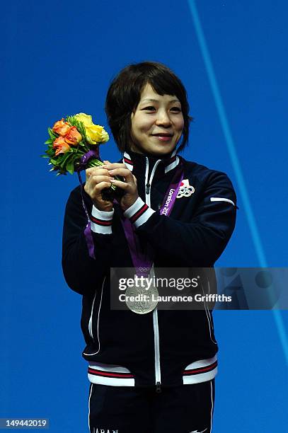 Hiromi Miyake of Japan celebrates on the podium after winning the silver medal in the Women's 48kg Group A weightlifting on Day 1 of the London 2012...