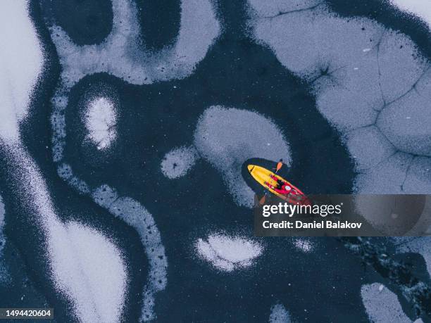 people in nature. kayaking in frozen lake. - kayaking aerial stock pictures, royalty-free photos & images