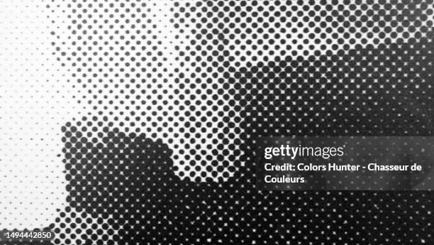 macro photograph of grey and black dots printed on a white poster pasted on a wall in paris, france - newspaper photos et images de collection