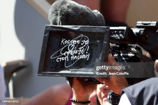 Novak Djokovic of Serbia writes in Serbian on the camera lens a political statement, 'Kosovo is the heart of Serbia. Stop the violence' about the...