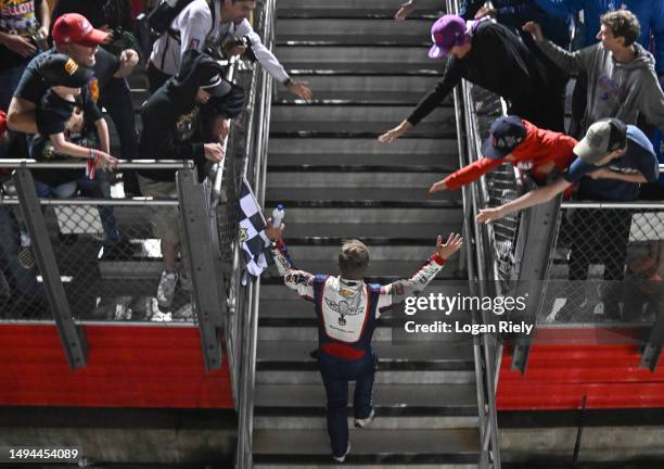 Justin Allgaier, driver of the Unilever Military DeCA RCPT Chevrolet, celebrates with fans after winning the NASCAR Xfinity Series Alsco Uniforms 300...