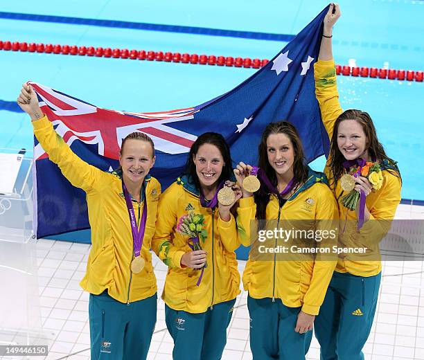 Melanie Schlanger, Alicia Coutts, Brittany Elmslie and Cate Campbell of Australia celebrate with their gold medalis and their counrty's flag during...