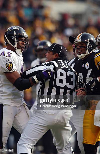 Back judge Richard Reels attempts to settle a dispute between Coery Harris of the Baltimore Ravens and Hines Ward of the Pittsburgh Steelers during...