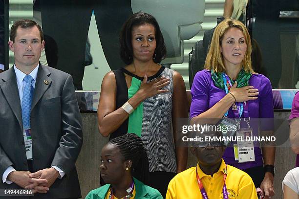 First Lady Michelle Obama stands during the playing of the US national anthem in the swimming competition at the London 2012 Olympic Games on July...