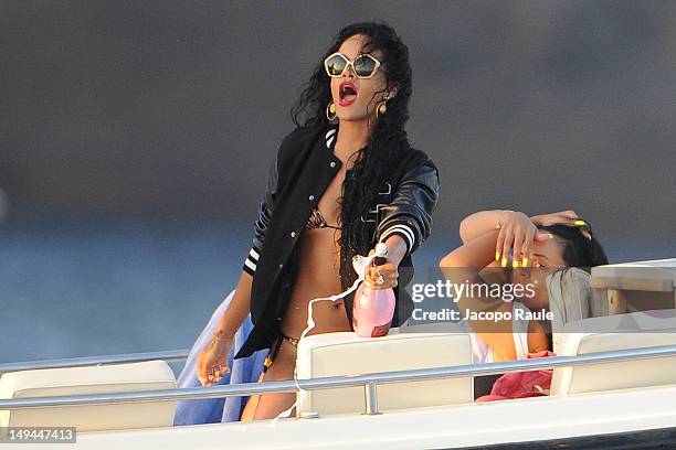 Rihanna is seen opening a bottle on a boat on July 28, 2012 in Portofino, Italy.