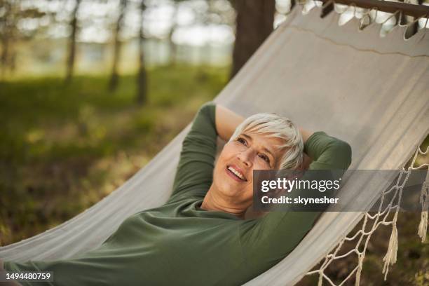 feliz día de la mujer mayor soñando en hamaca. - woman day dreaming fotografías e imágenes de stock