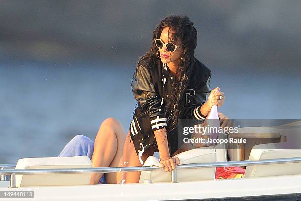 Rihanna is seen opening a bottle on a boat on July 28, 2012 in Portofino, Italy.