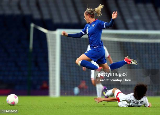 Camille Abily of France is tackled by Chung Sim of DPR Korea during the Women's Football first round Group G match between France and DPR Korea on...