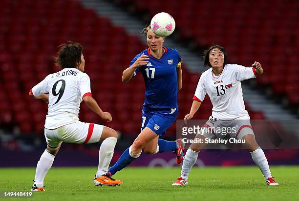Gaetane Thiney of France is checked by Choe Mi Gyong and O Hui Sun of DPR Korea during the Women's Football first round Group G match between France...