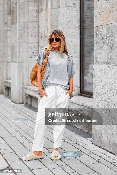 Influencer Gitta Banko, wearing a light grey T-shirt by Extreme Cashmere, white pants by Nili Lotan, a silver-grey vest by Free City, beige shag...