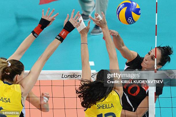 Turkey's Gozde Sonsirma spikes as Brazil's Sheilla Castro and Thaisa Menezes attempt to block during the women's volleyball match between Turkey and...
