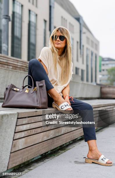 Influencer Gitta Banko, wearing a beige leeveless hoodie by Roberto Collina, dark grey pants by Nili Lotan, sandals by Chanel, a brown bag by Hermes...